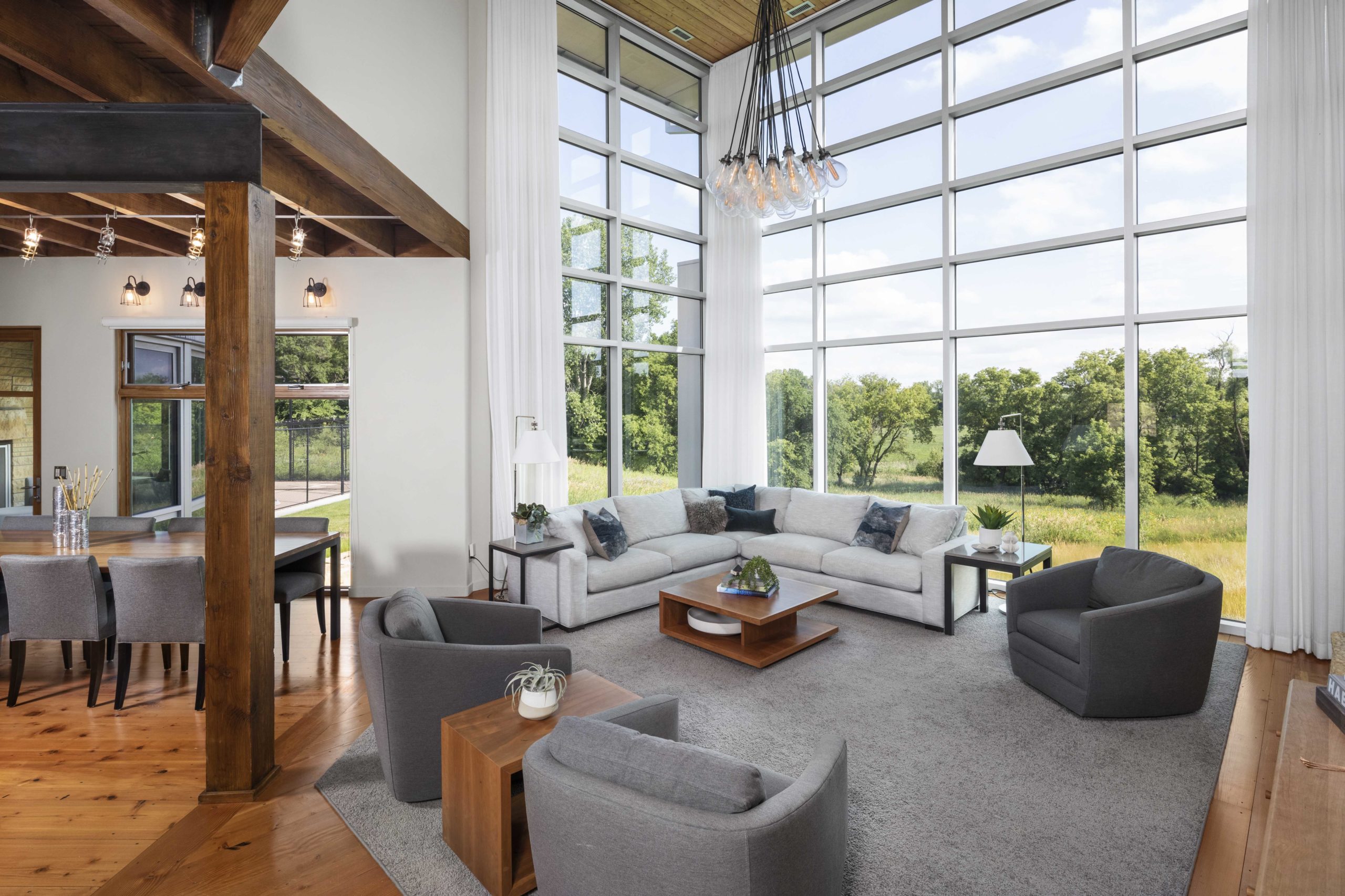 A contemporary living room with large windows overlooking a field.