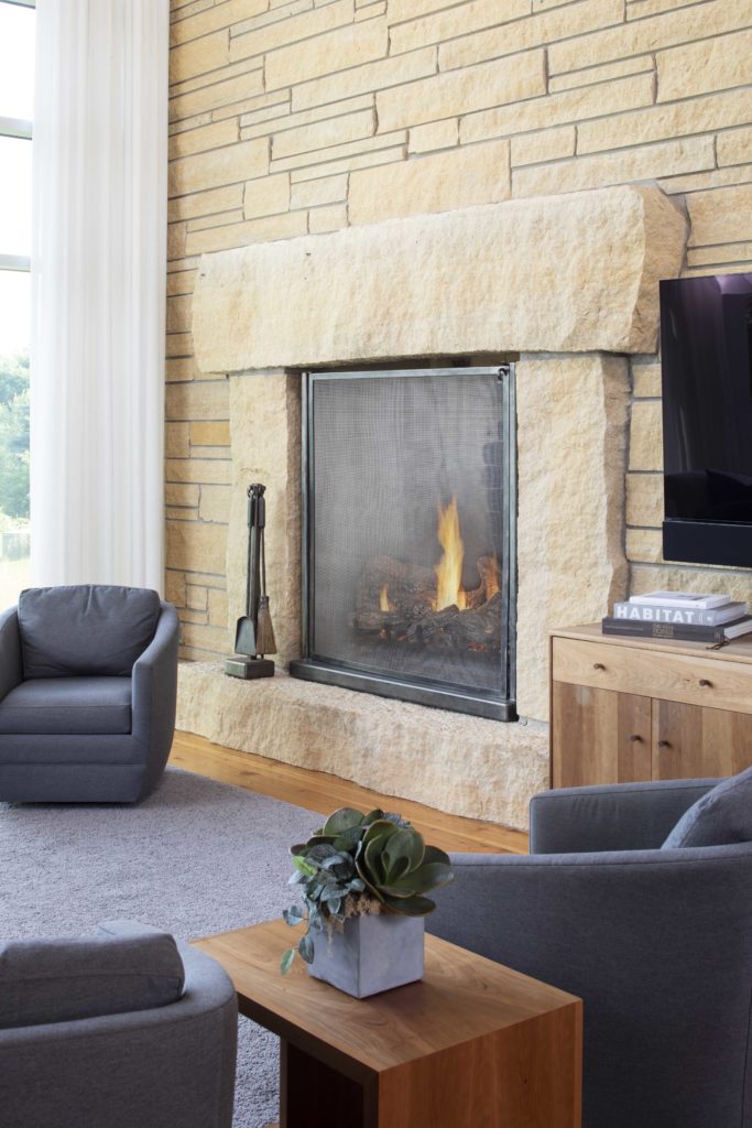 A contemporary living room with a farmhouse-style fireplace.