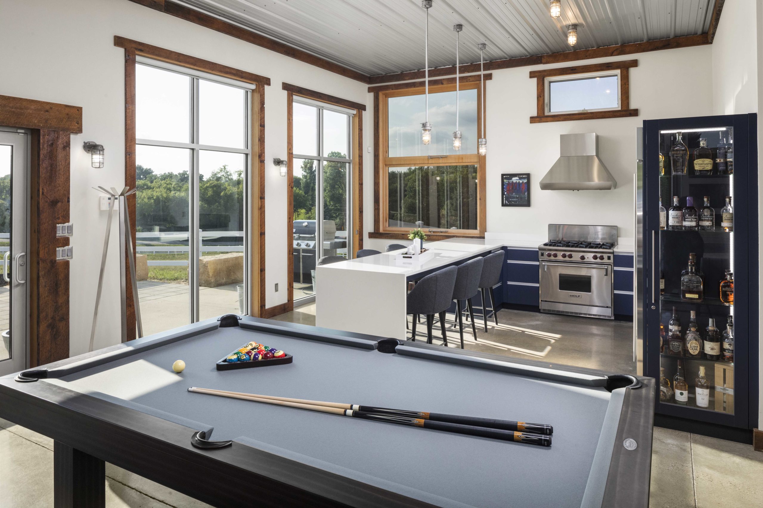 A contemporary game room with a pool table and billiards, featuring a farmhouse-inspired design.