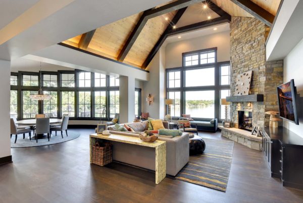 Lake house plans: A large living room with wood beams and a fireplace.
