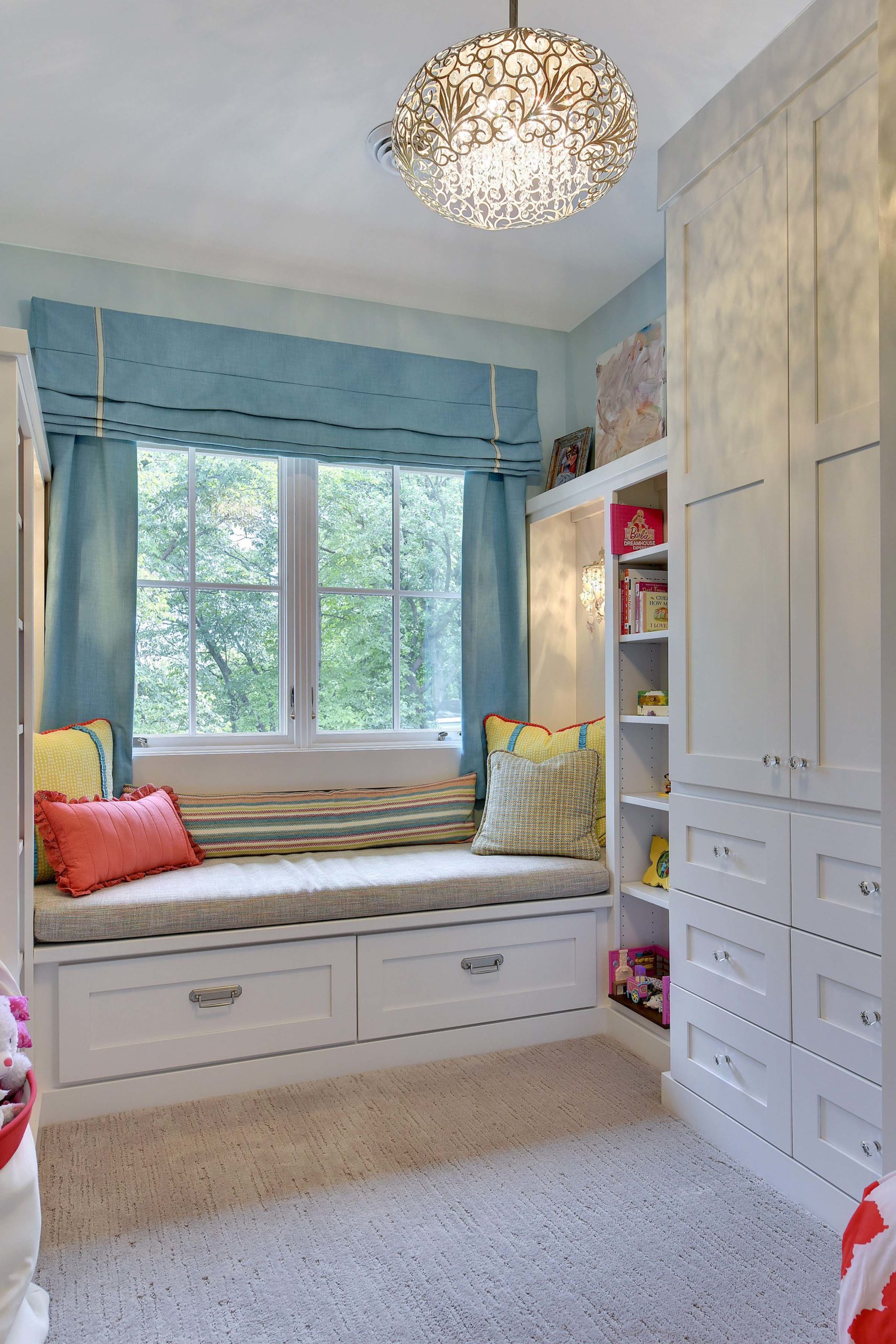 A contemporary child's bedroom with a window seat and closet.