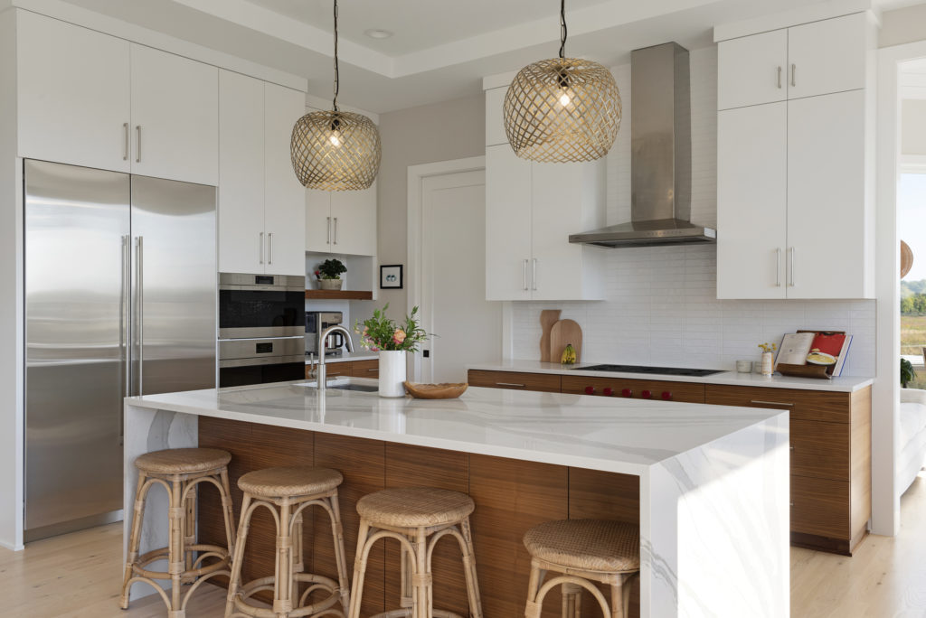 A prairie-inspired kitchen with a center island and stools in a modern custom home.