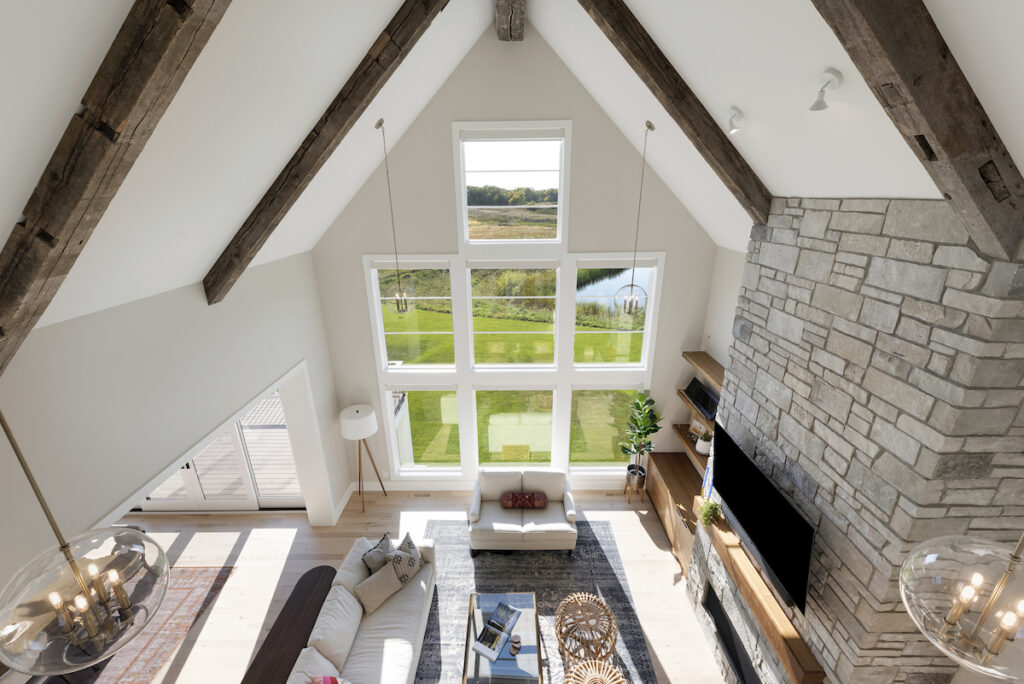 An aerial view of a prairie-style living room with wood beams in a custom home.