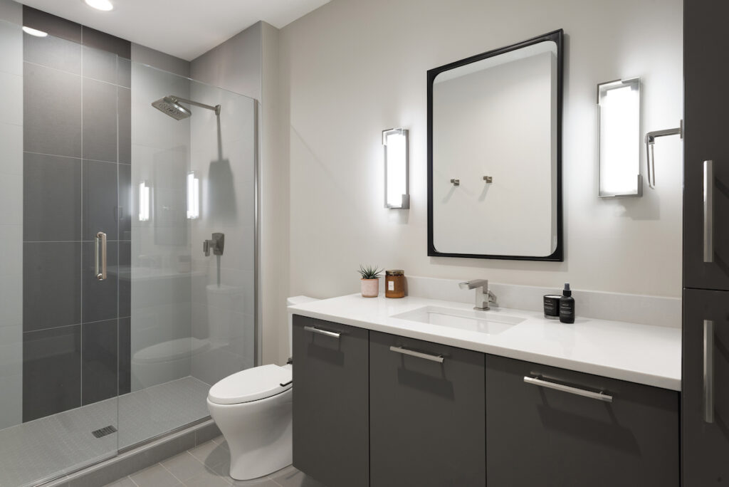 A prairie transitional custom home with a modern bathroom featuring a glass shower stall.