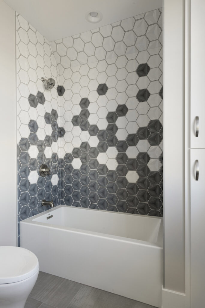 A prairie transitional custom home bathroom with black and white hexagon tiles.