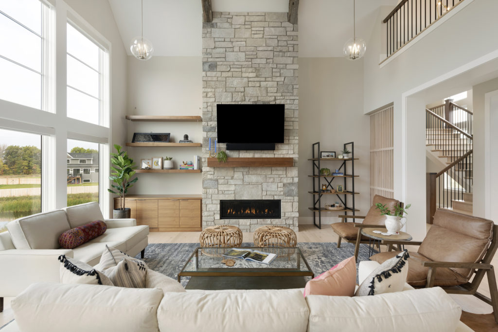 A prairie transitional living room with a stone fireplace and tv.