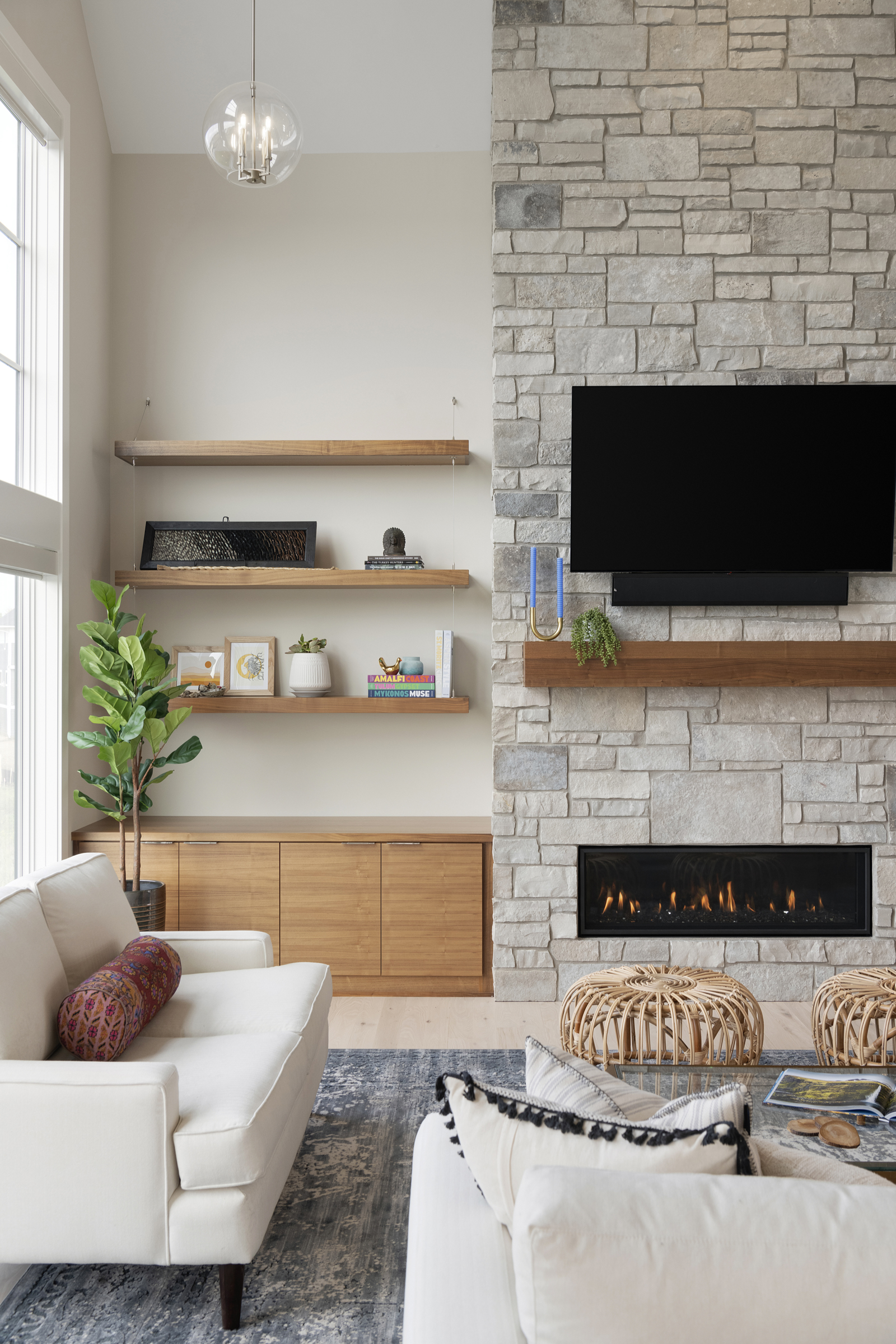 A prairie transitional living room with a stone fireplace and white furniture.