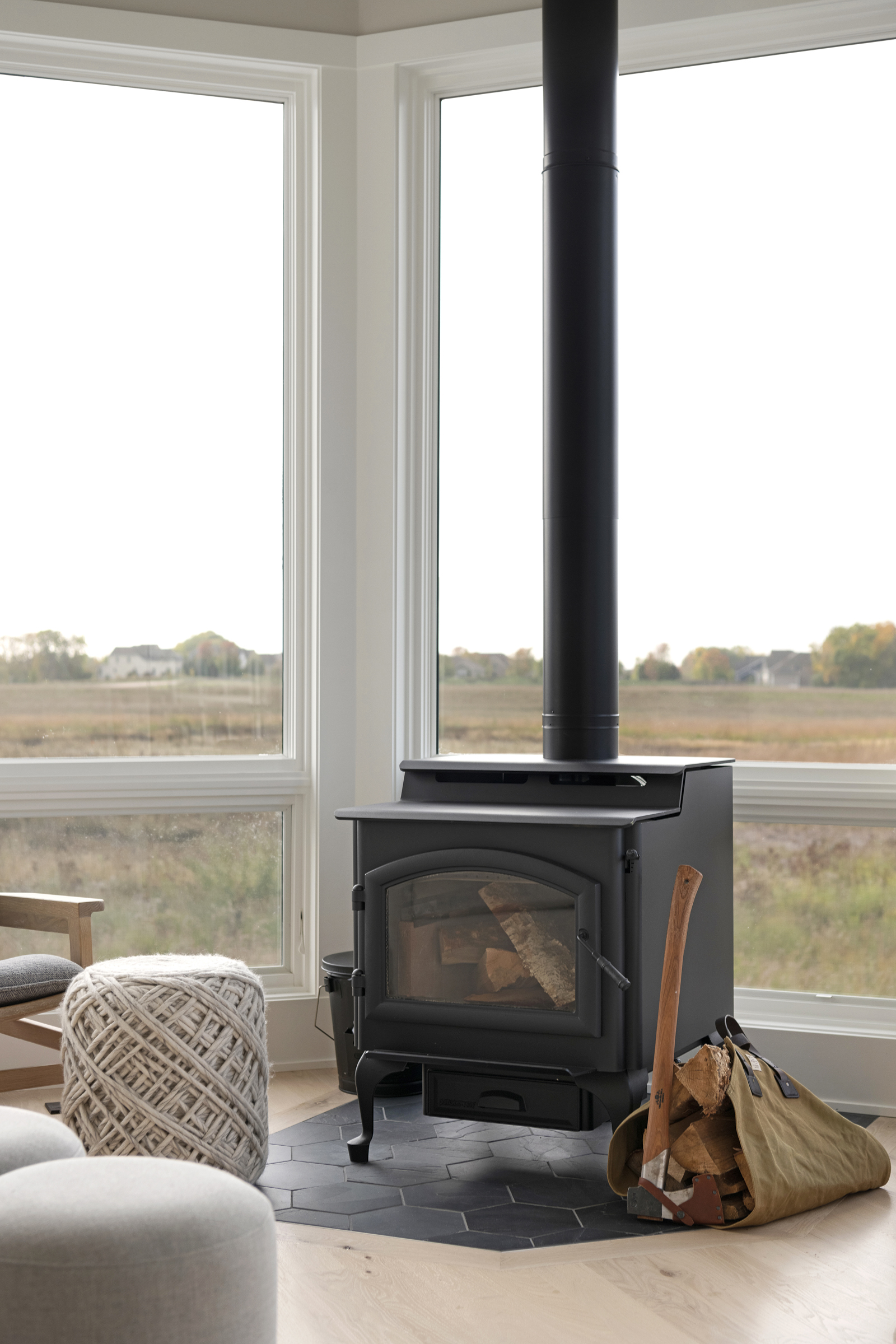 A prairie-style wood burning stove enhances the cozy ambiance of a transitional living room in a custom home.