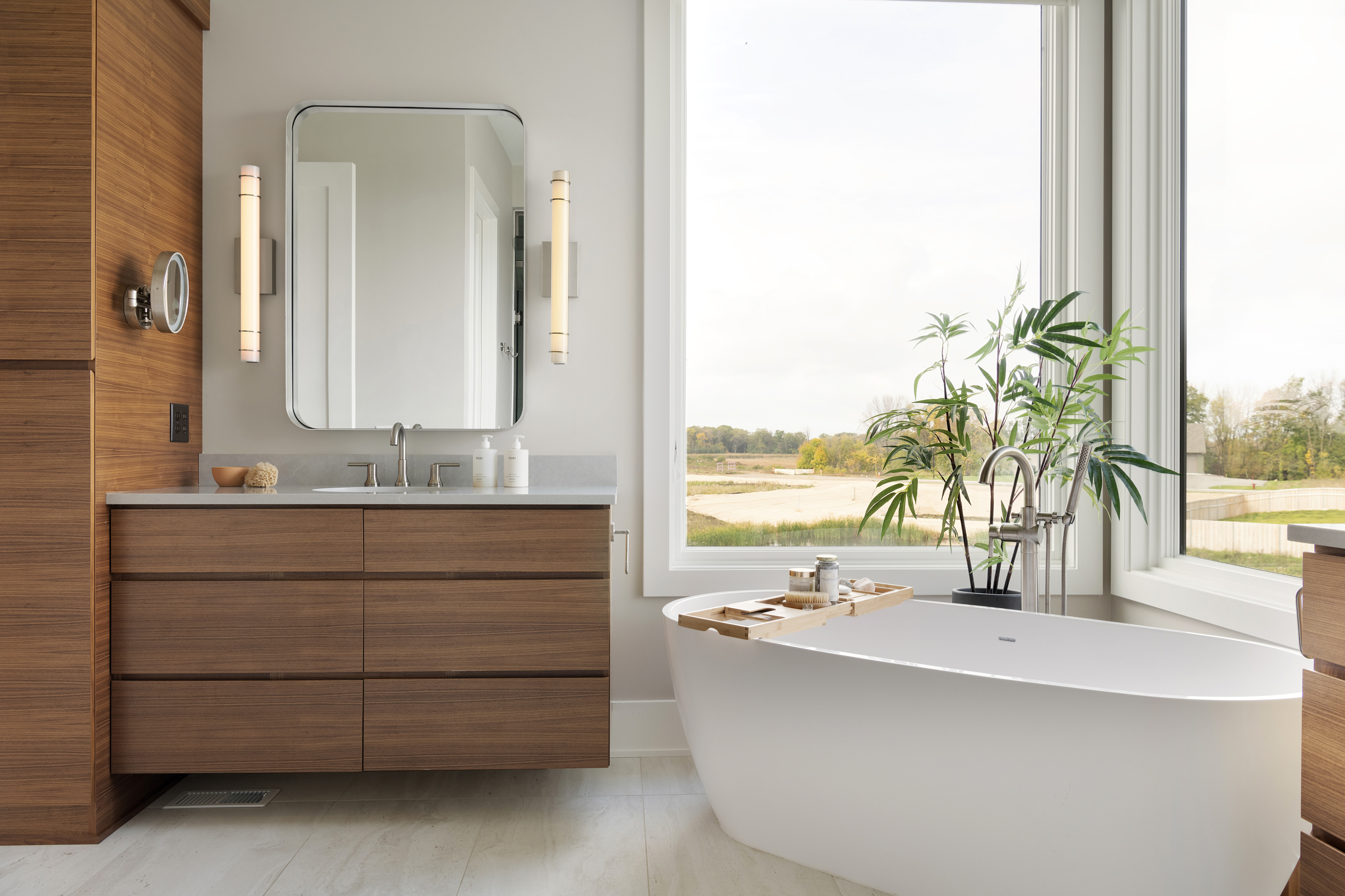 A prairie transitional custom home with a modern bathroom featuring wooden cabinets and a bathtub.