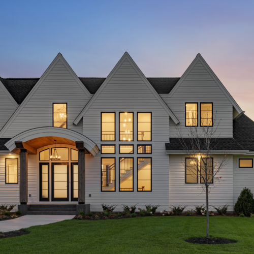 The exterior of a prairie transitional custom home at dusk.