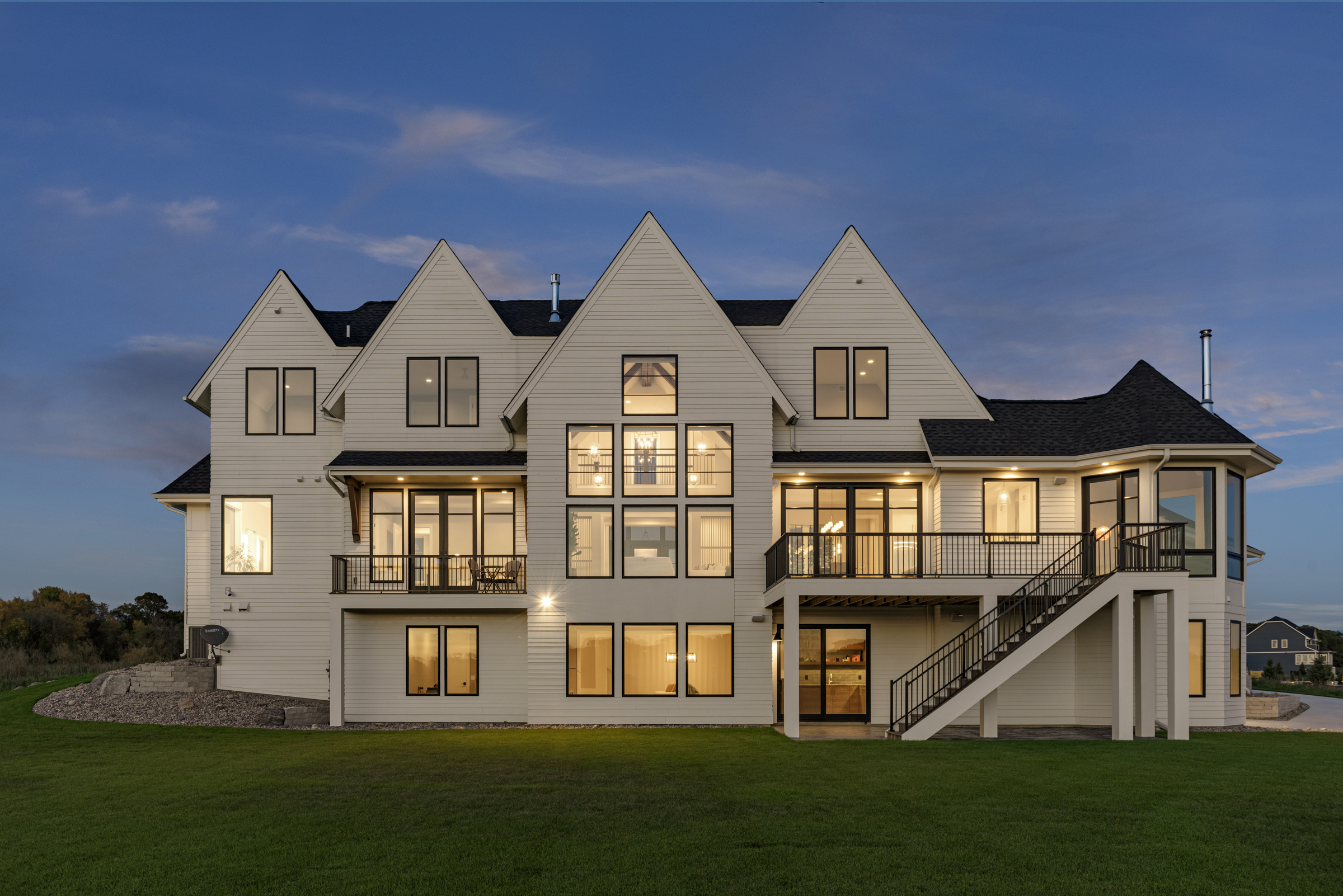The exterior of a transitional custom home at dusk.