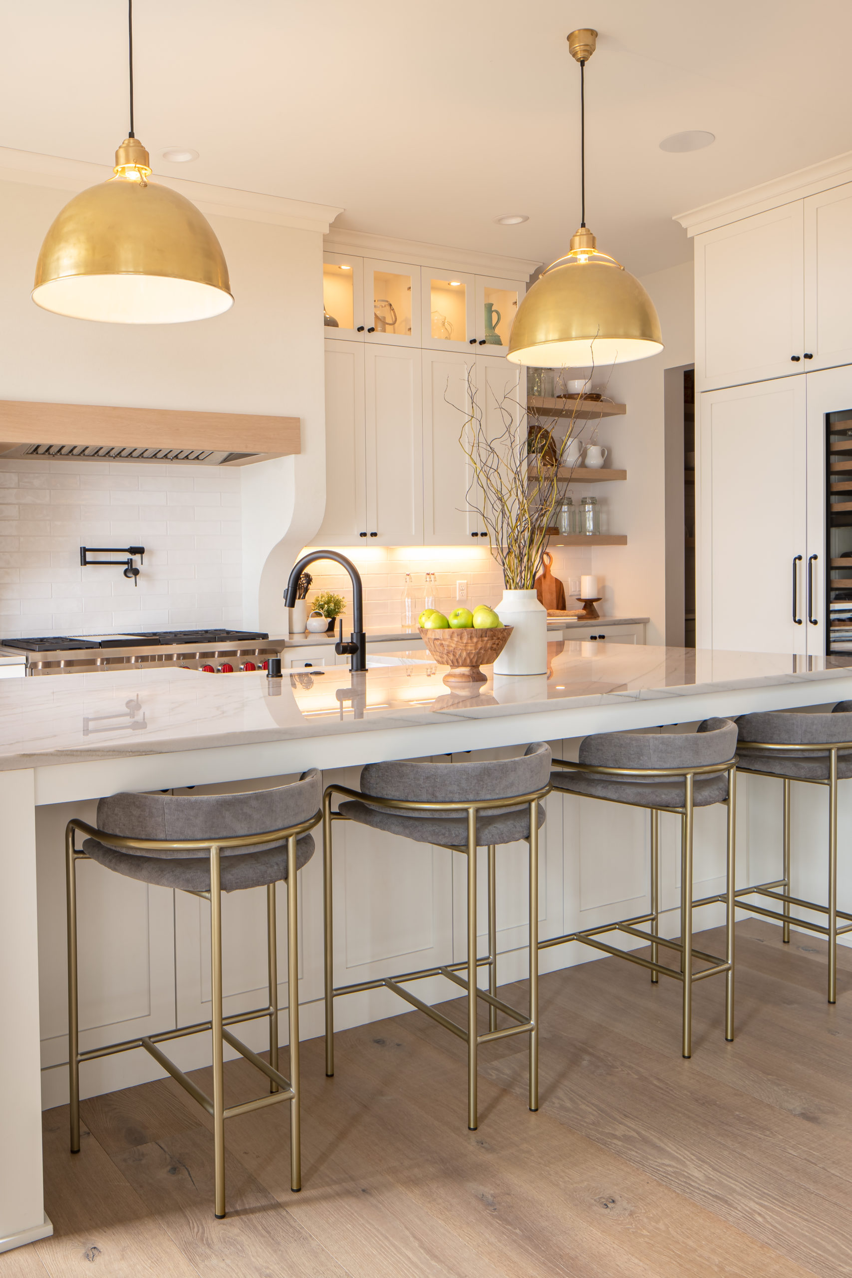 A kitchen with a large island and bar stools, part of The Lake Escape custom home remodel.