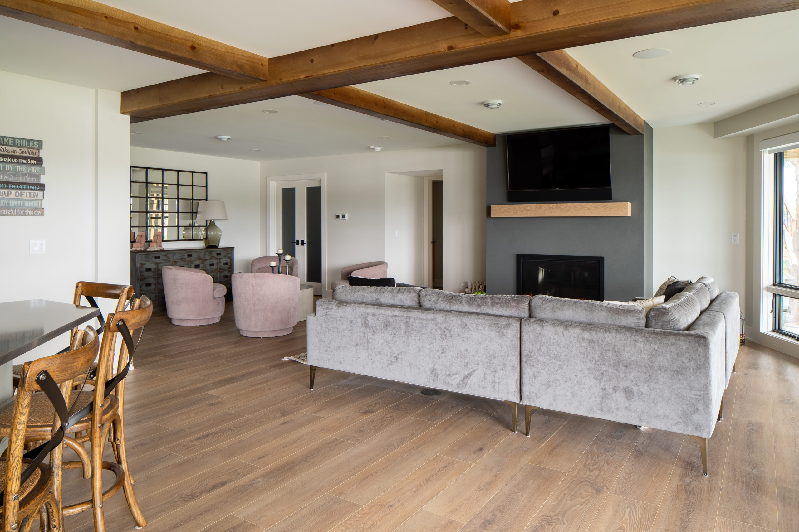 The Lake Escape custom home remodel now features a cozy living room with wood beams and a fireplace.