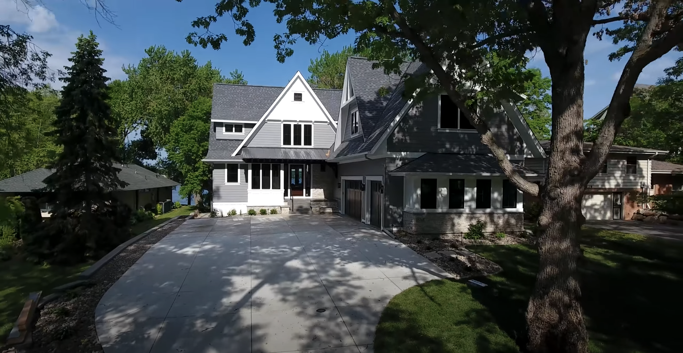 A Custom Home Build Video Series showcasing an aerial view of a home with a driveway and trees.