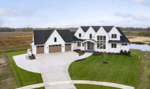 A captivating aerial view of a custom home with a sprawling driveway.