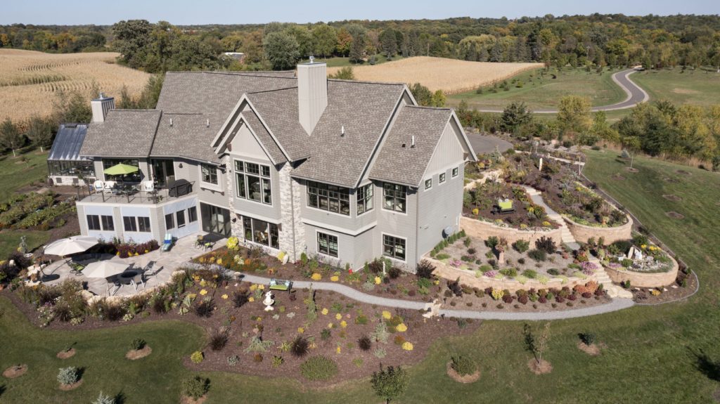 An aerial view of a prairie-style home in the countryside.