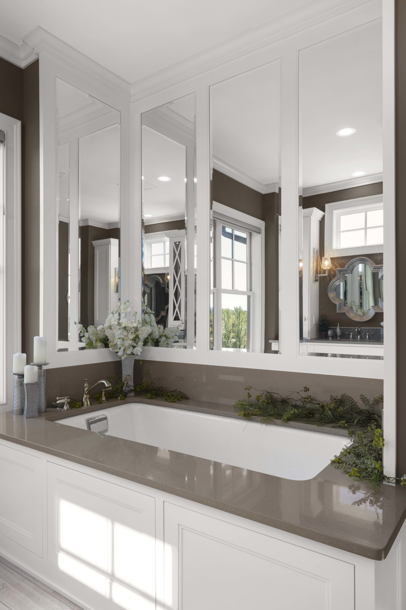 A prairie-style bathroom with a large tub and mirrors in a custom home.