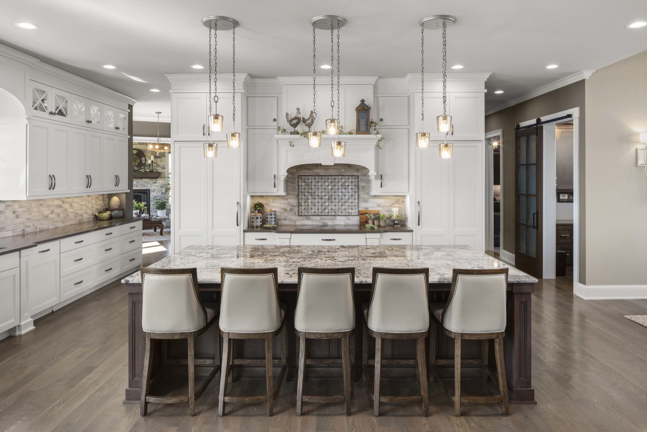 A prairie transitional custom home with a large kitchen featuring a center island and bar stools.