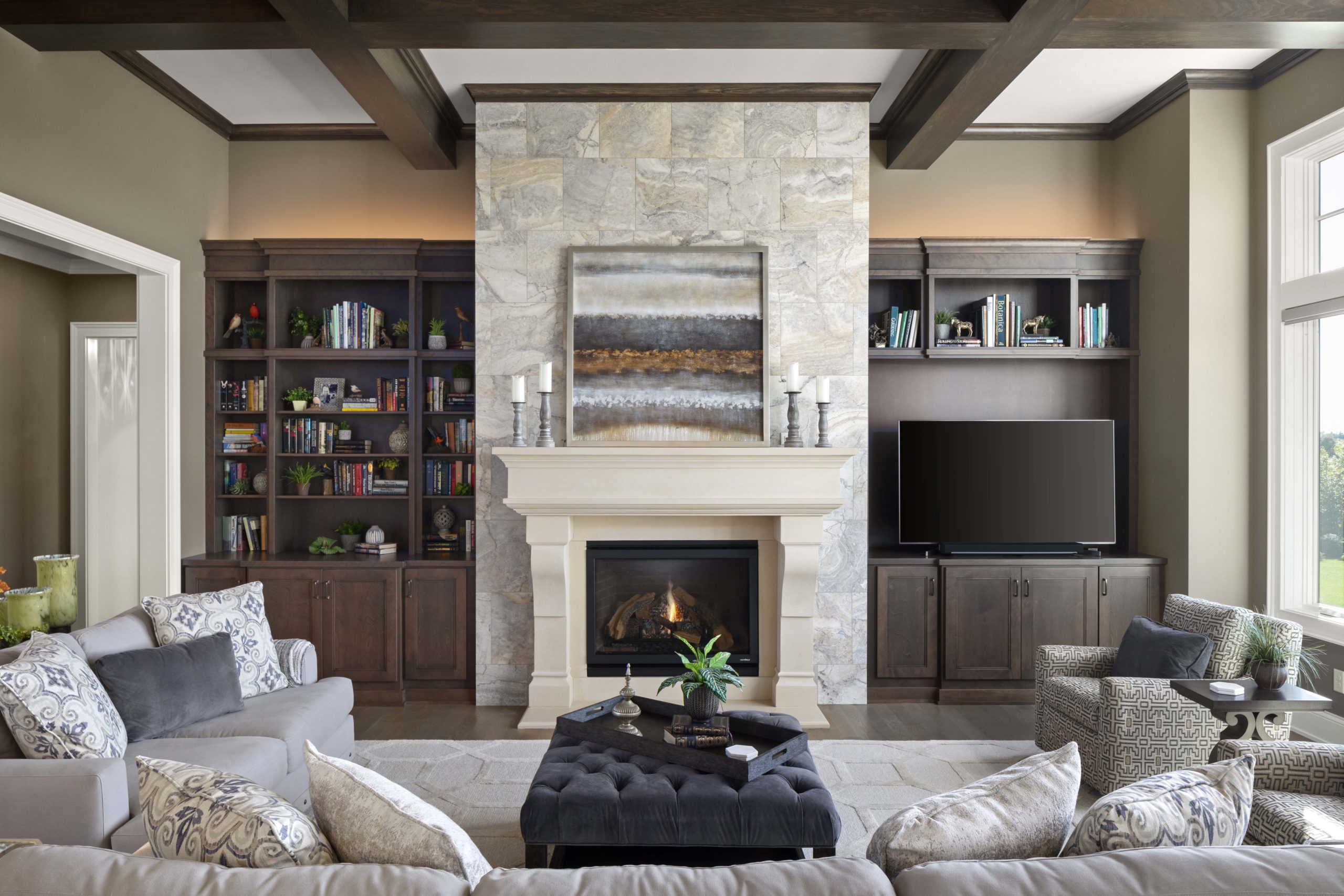 A prairie transitional living room with a stone fireplace and bookshelves in a custom home.