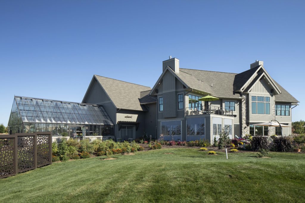 A prairie transitional custom home with a green lawn.