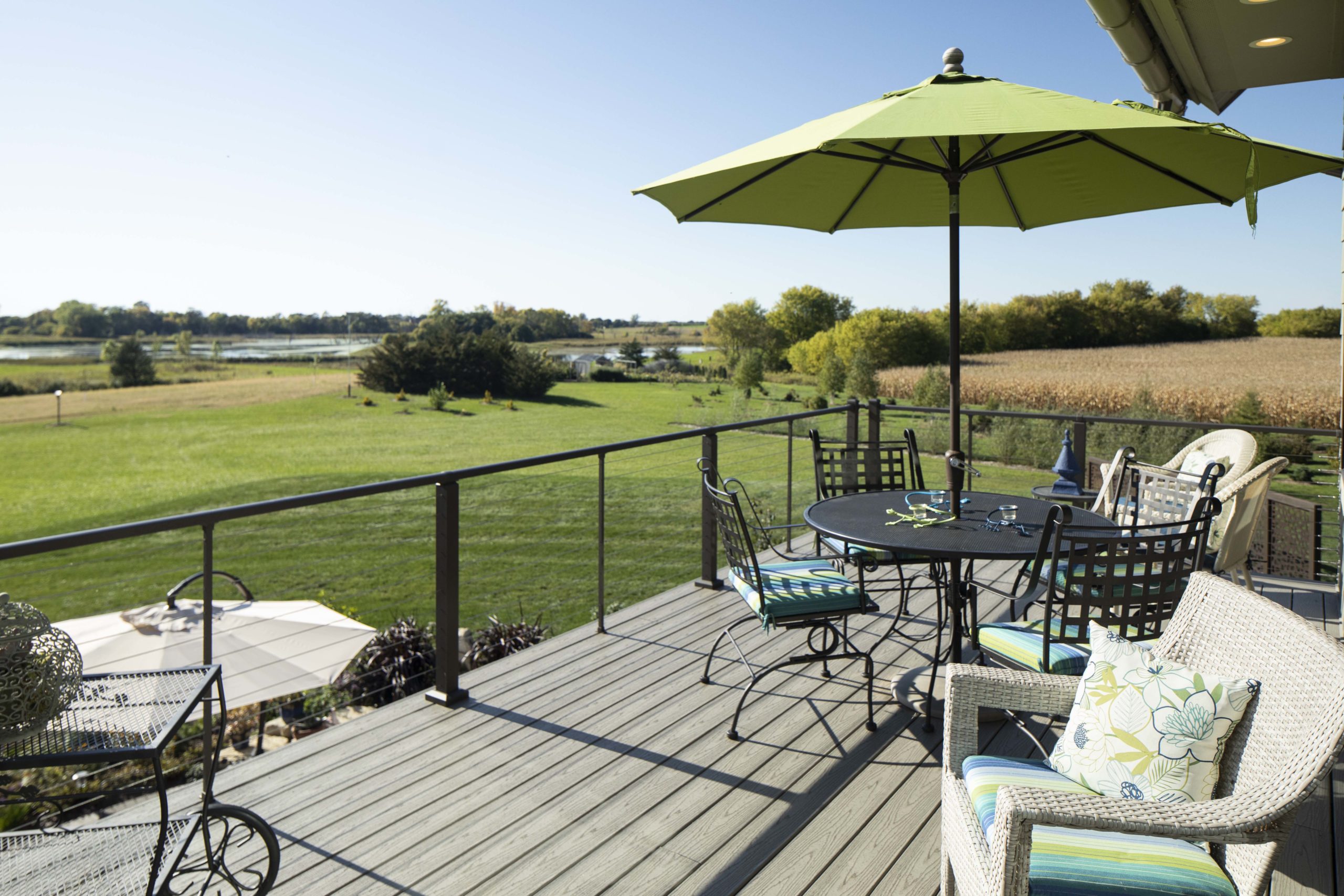 A prairie-style deck with a custom table and chairs, complete with an umbrella for shade.