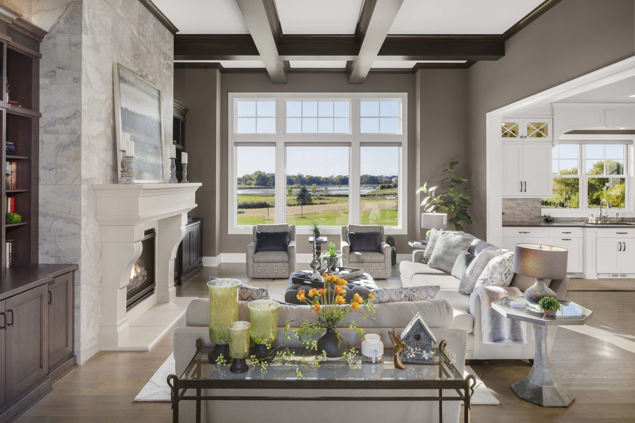 A prairie-style living room with a fireplace and large windows in a custom home.
