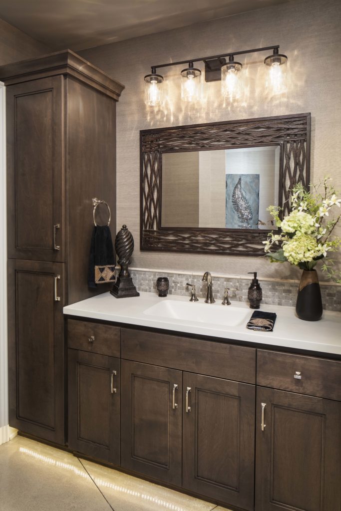 A prairie transitional bathroom with custom brown cabinets and a mirror.