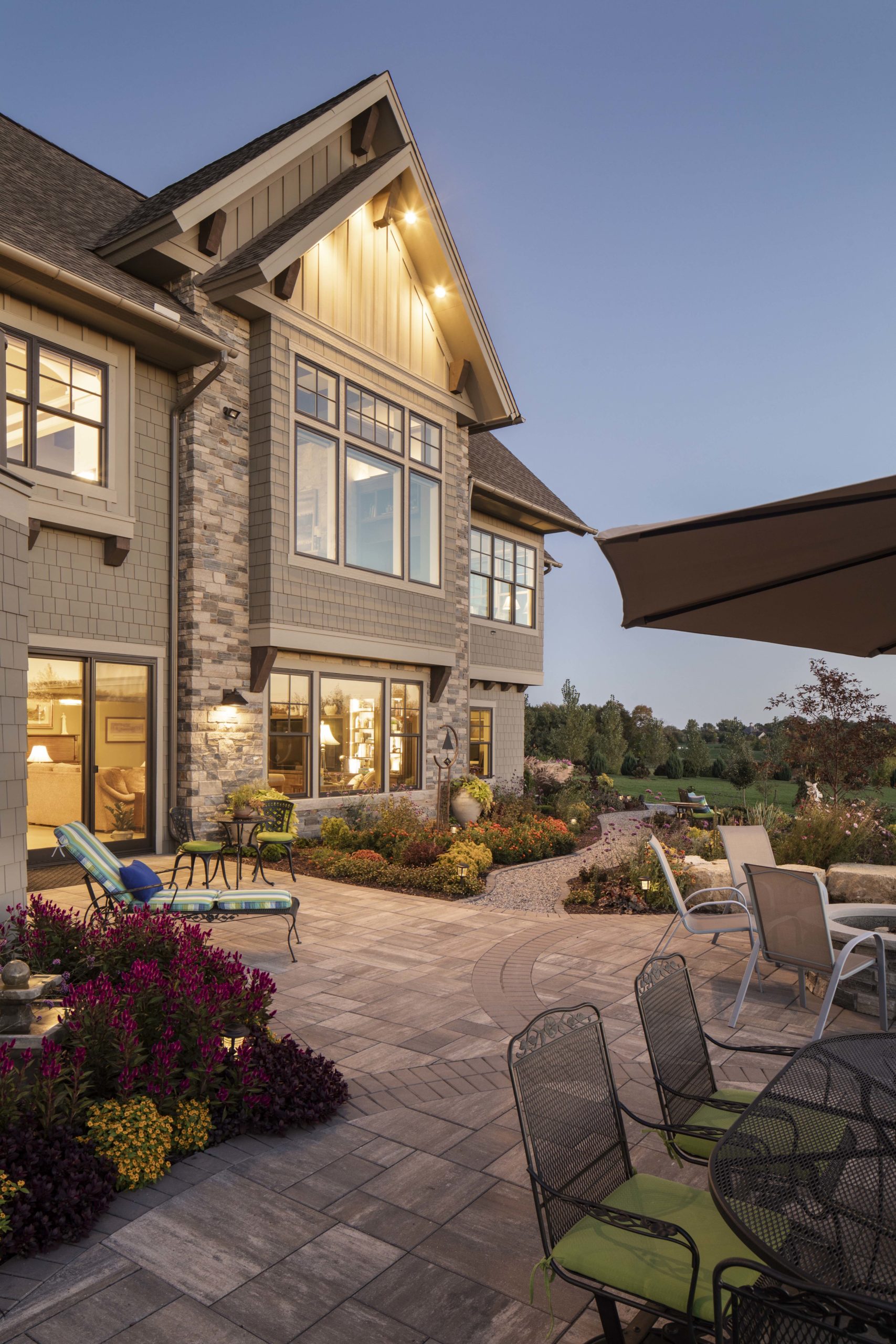 A prairie-style home with a patio and outdoor furniture at dusk.