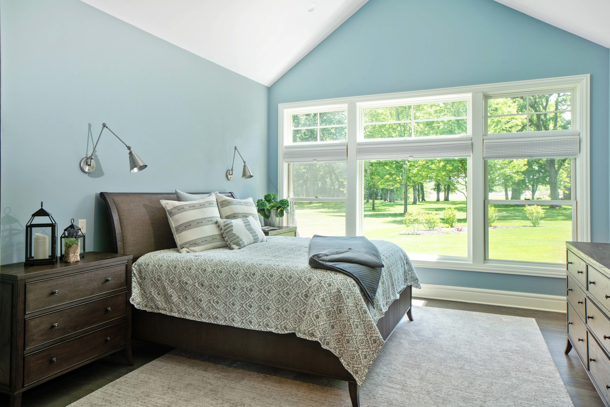 The Lake Escape custom home remodel featuring a bedroom with blue walls and a bed.