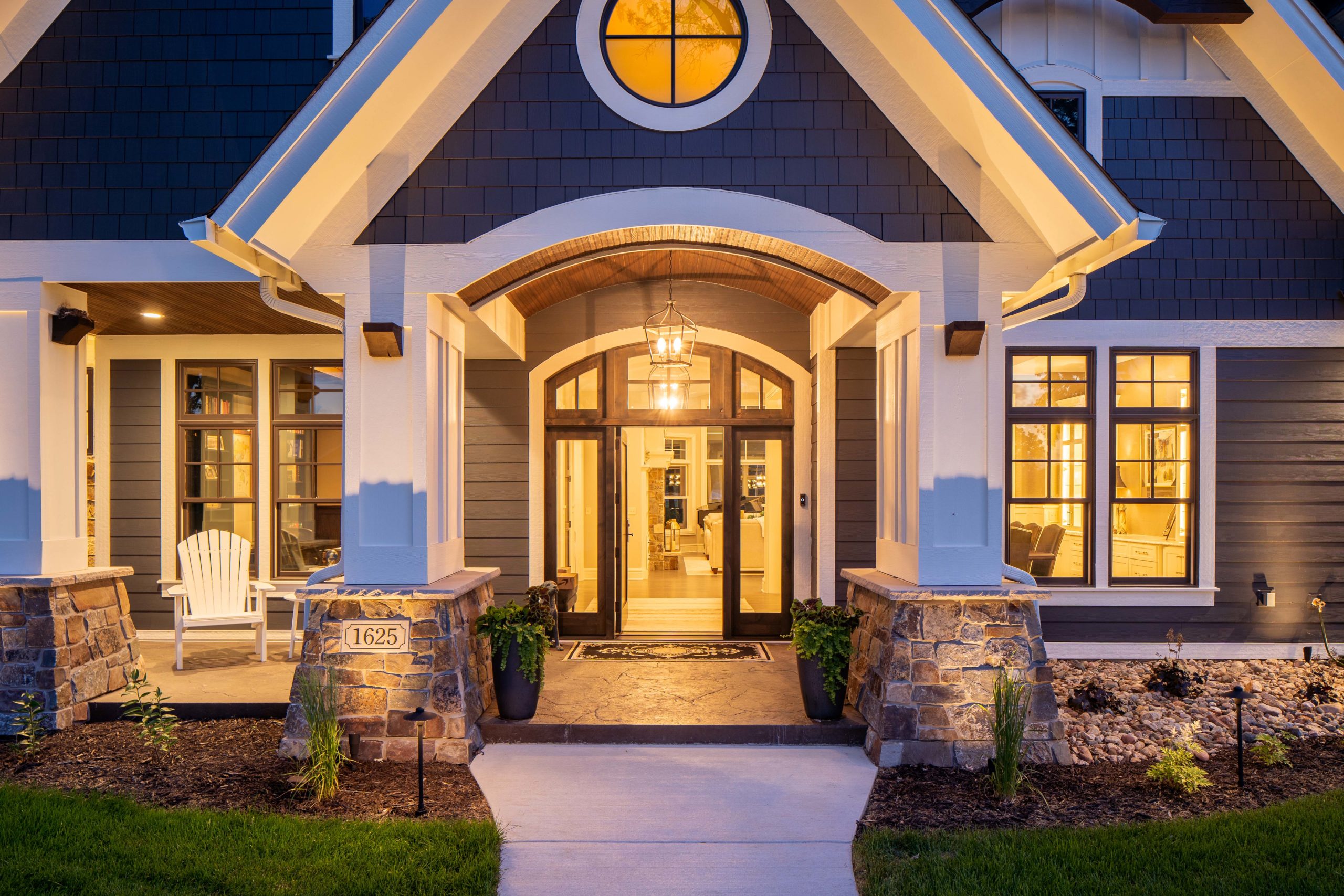 The Lake Escape custom home remodel featuring a front porch illuminated at night.