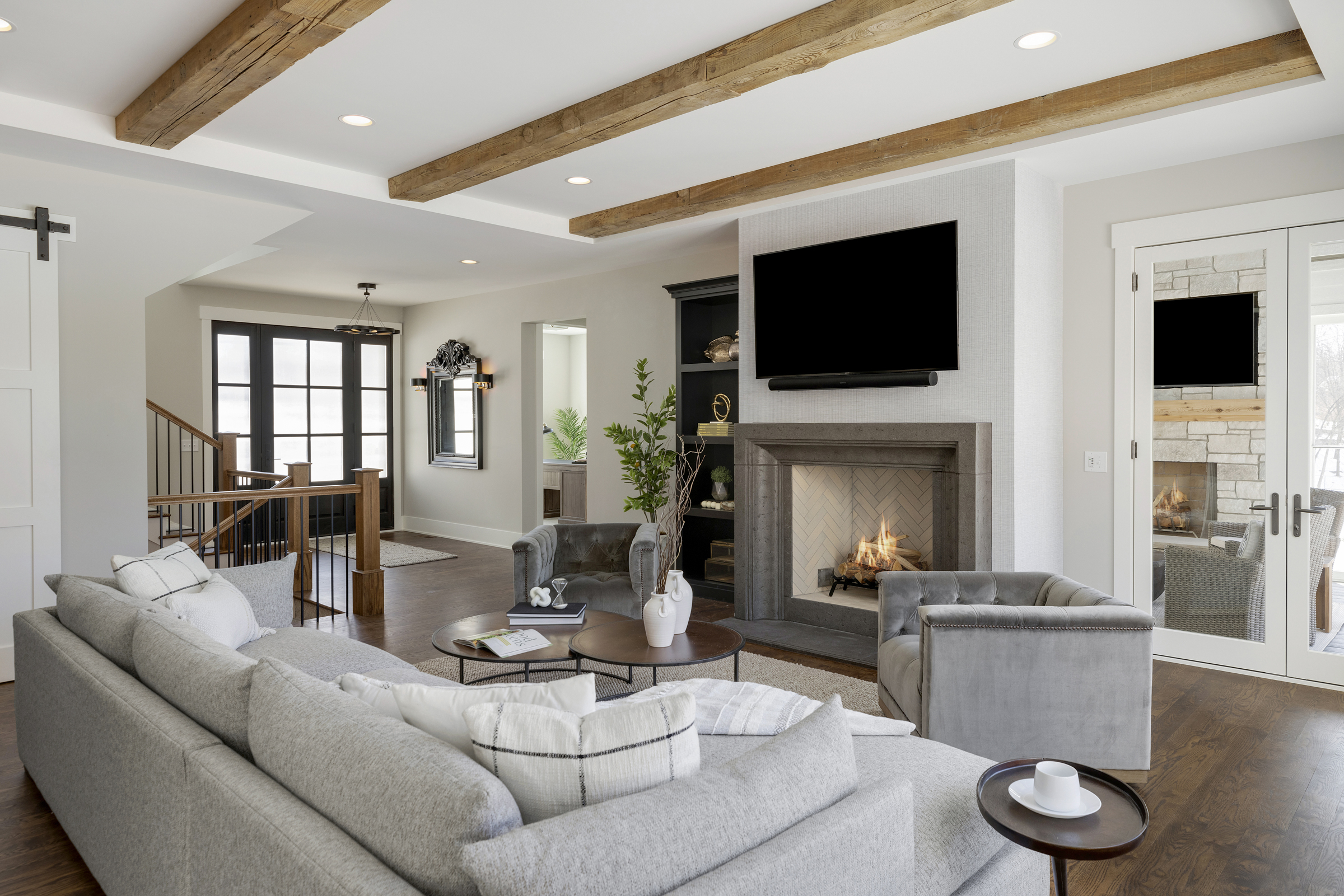 A living room with wood beams and a fireplace.