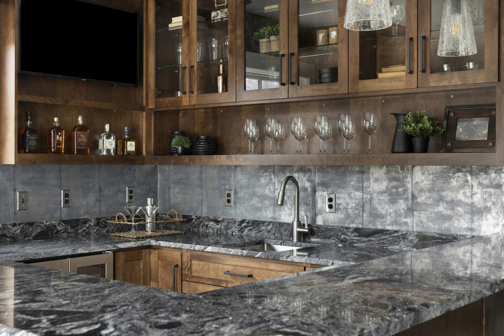 A kitchen with marble counter tops and wooden cabinets.