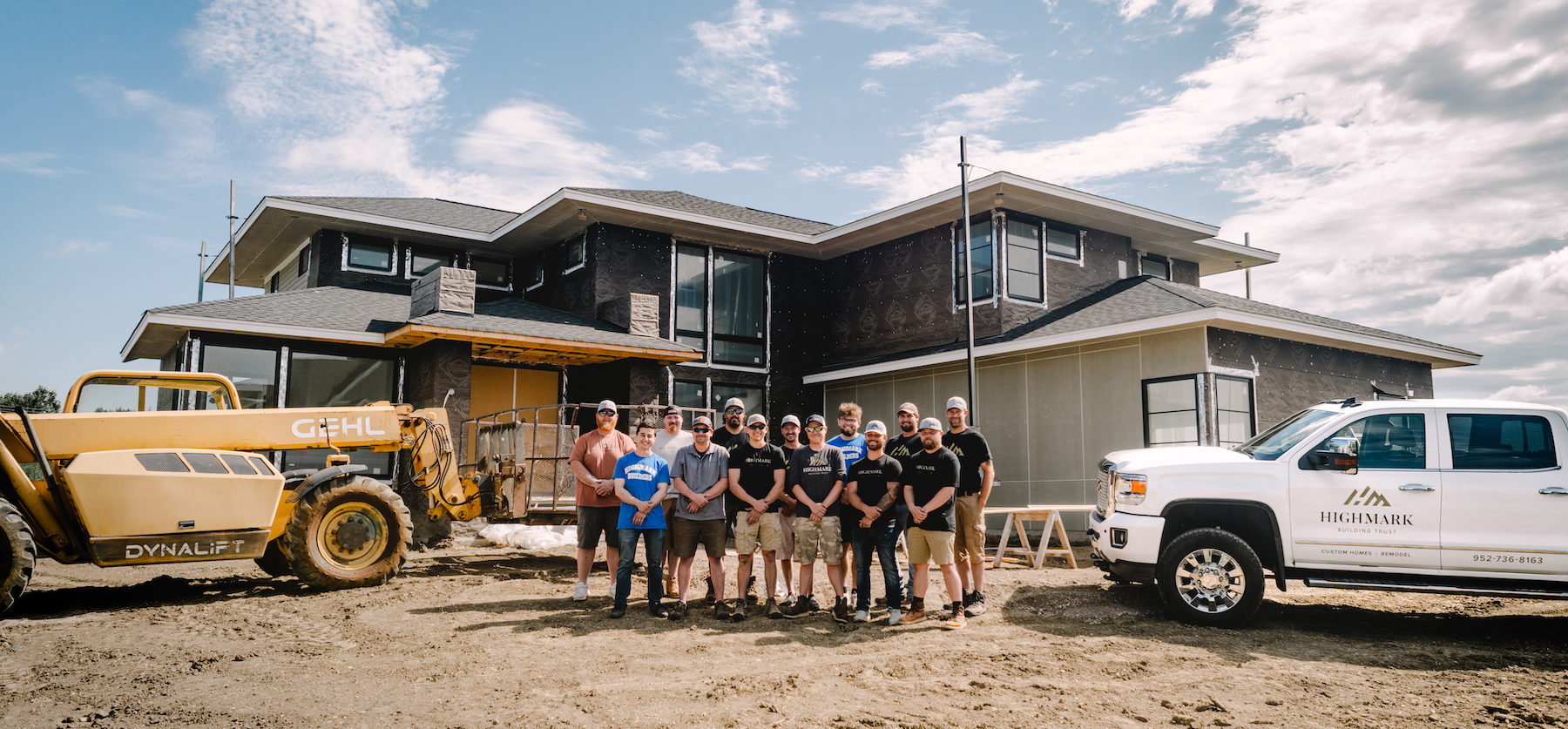 A group of construction workers standing in front of a house.