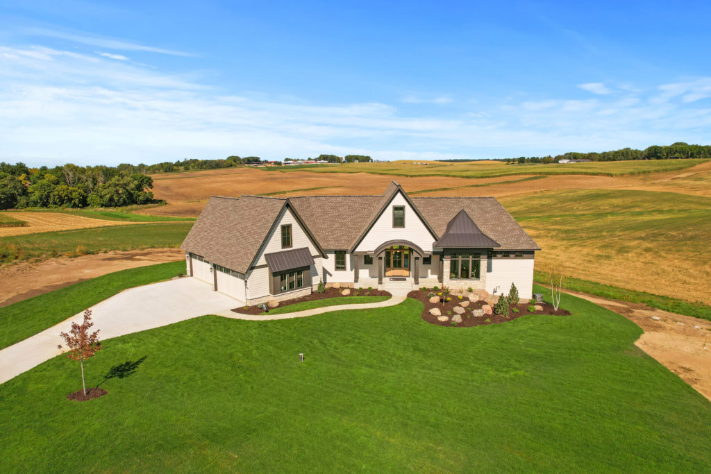 An aerial view of a custom home in a prairie field.