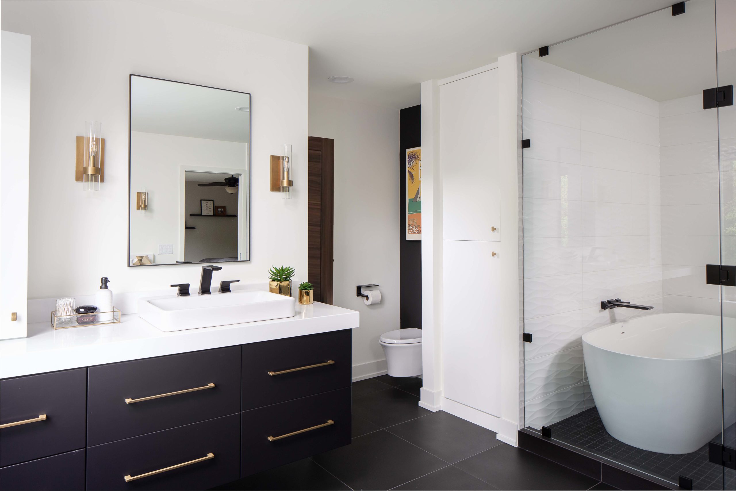 A modern black and white bathroom remodel featuring a tub and sink.