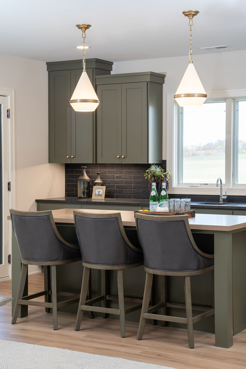 A prairie transitional kitchen with a center island and bar stools.