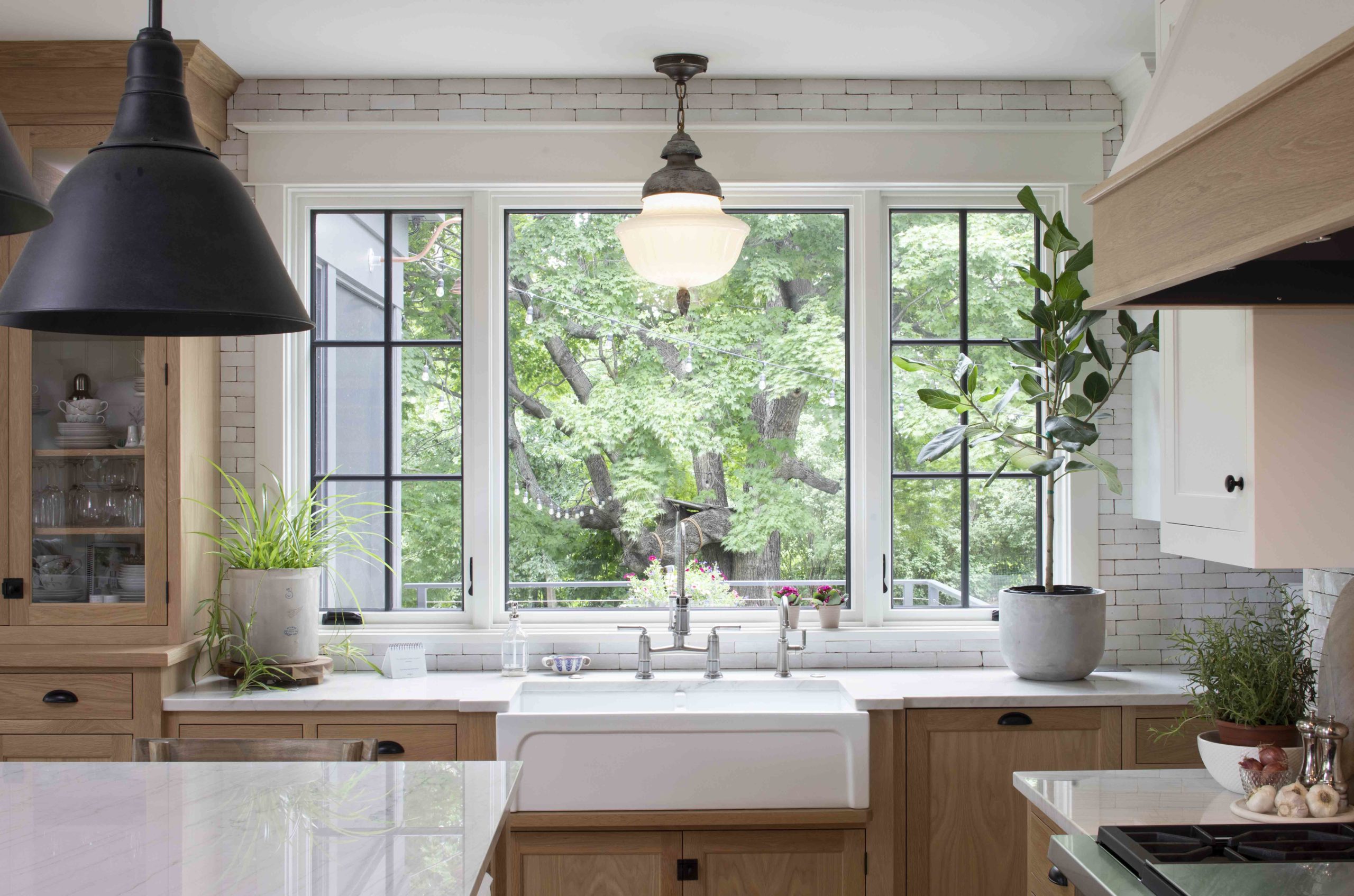 A transitional kitchen with a sink and a window in a custom home.