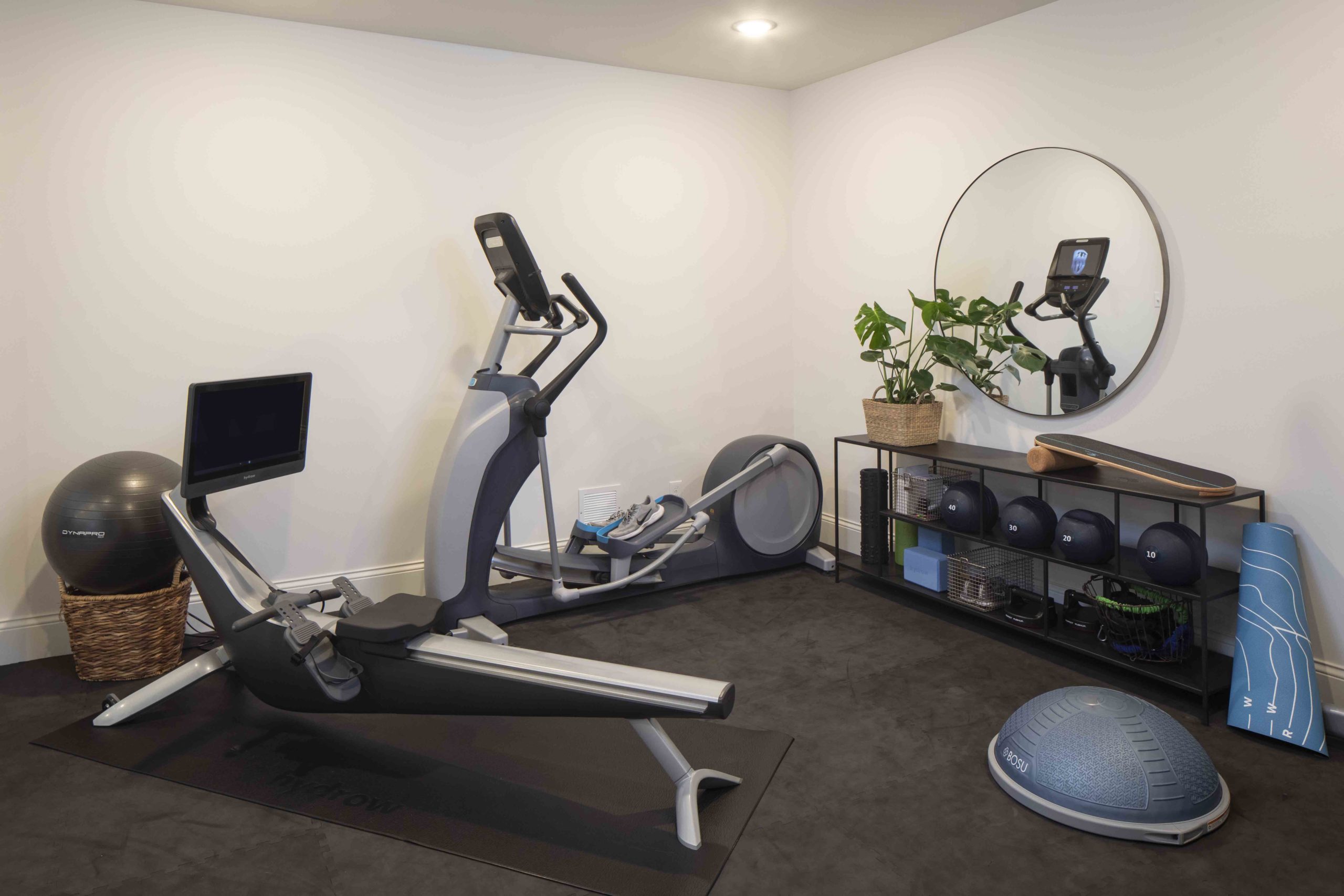 A prairie-style gym room with exercise equipment and a mirror.