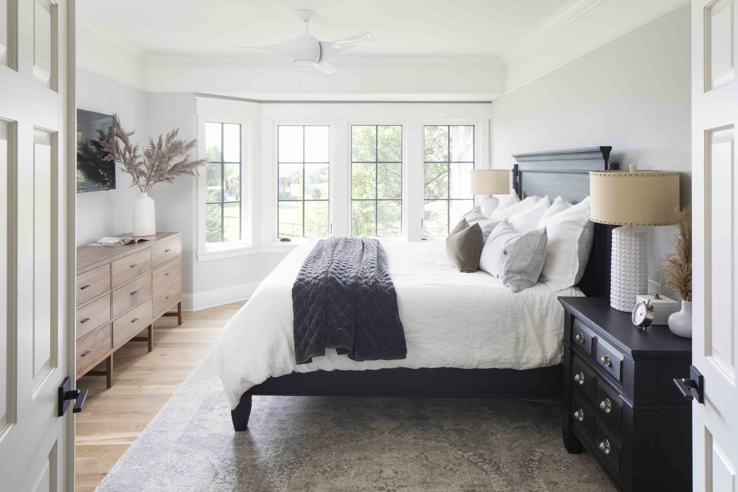 A prairie transitional custom home with a white bed and black dresser.