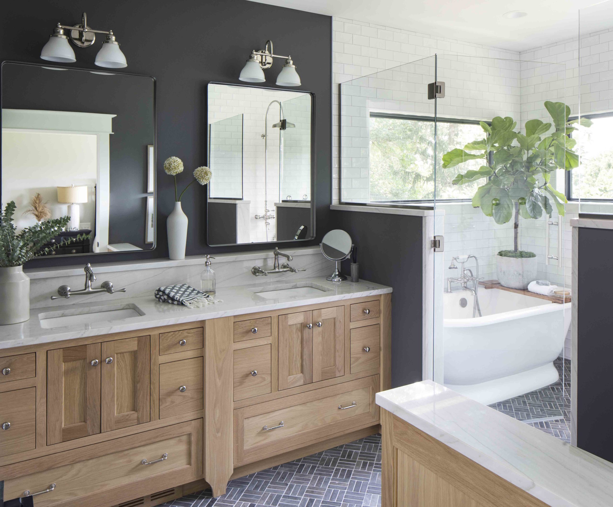 A prairie transitional custom home with a black and white bathroom featuring a tub and sink.