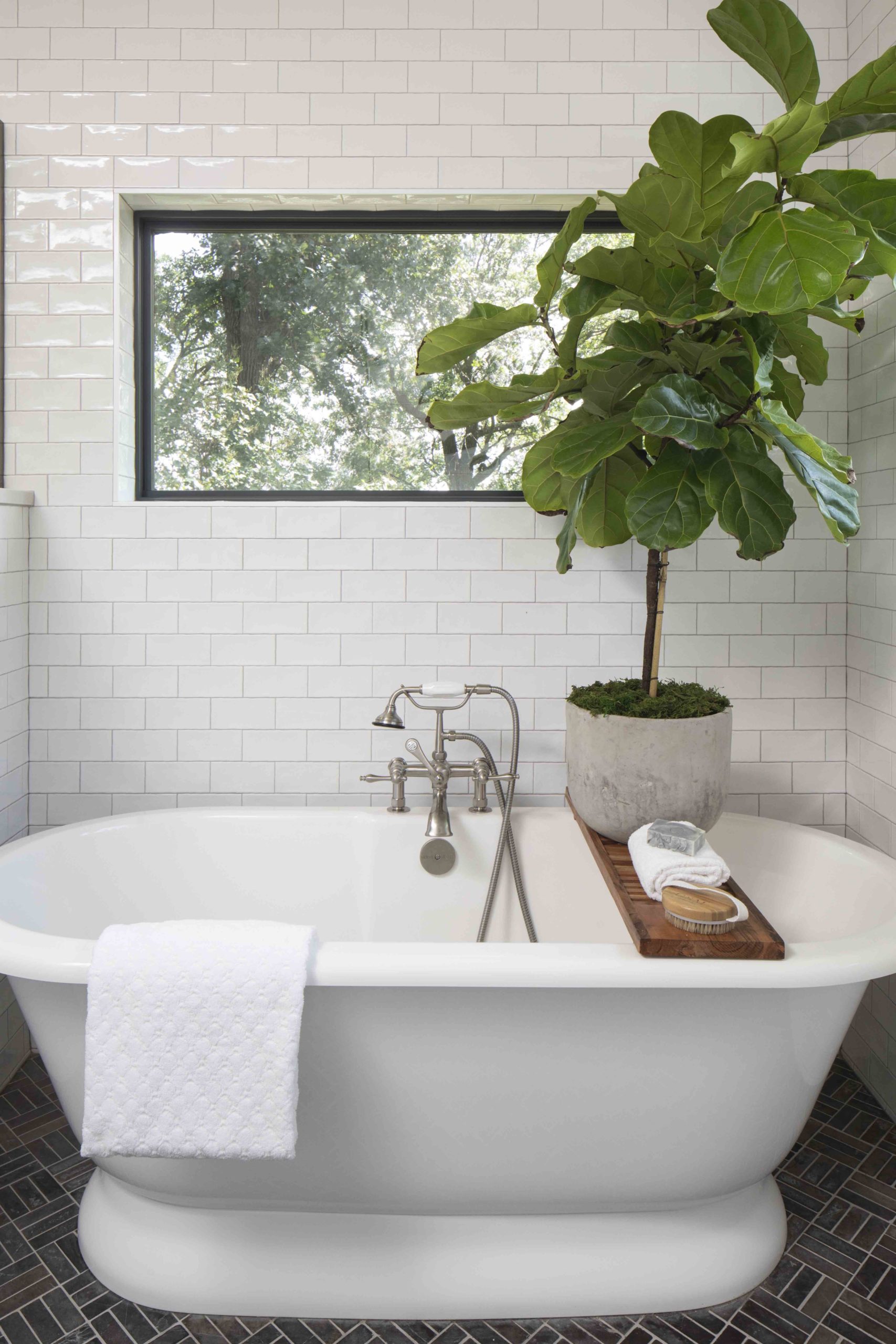 A white bathtub with a plant on top, nestled inside a prairie transitional custom home.