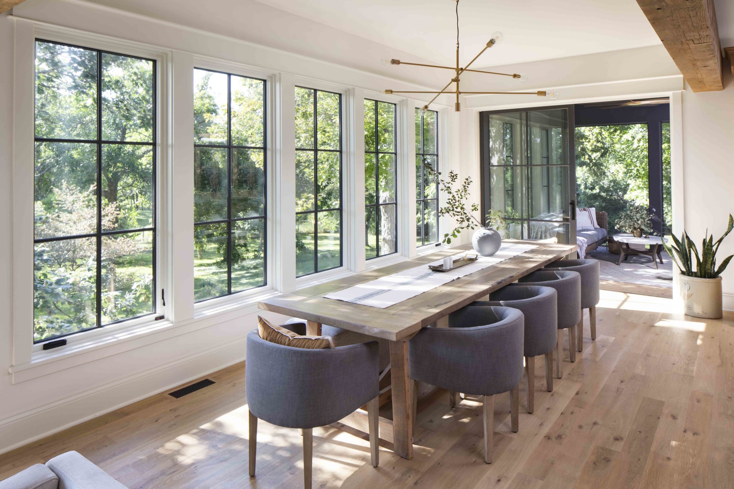 A prairie transitional custom home with large windows overlooking a wooded area.