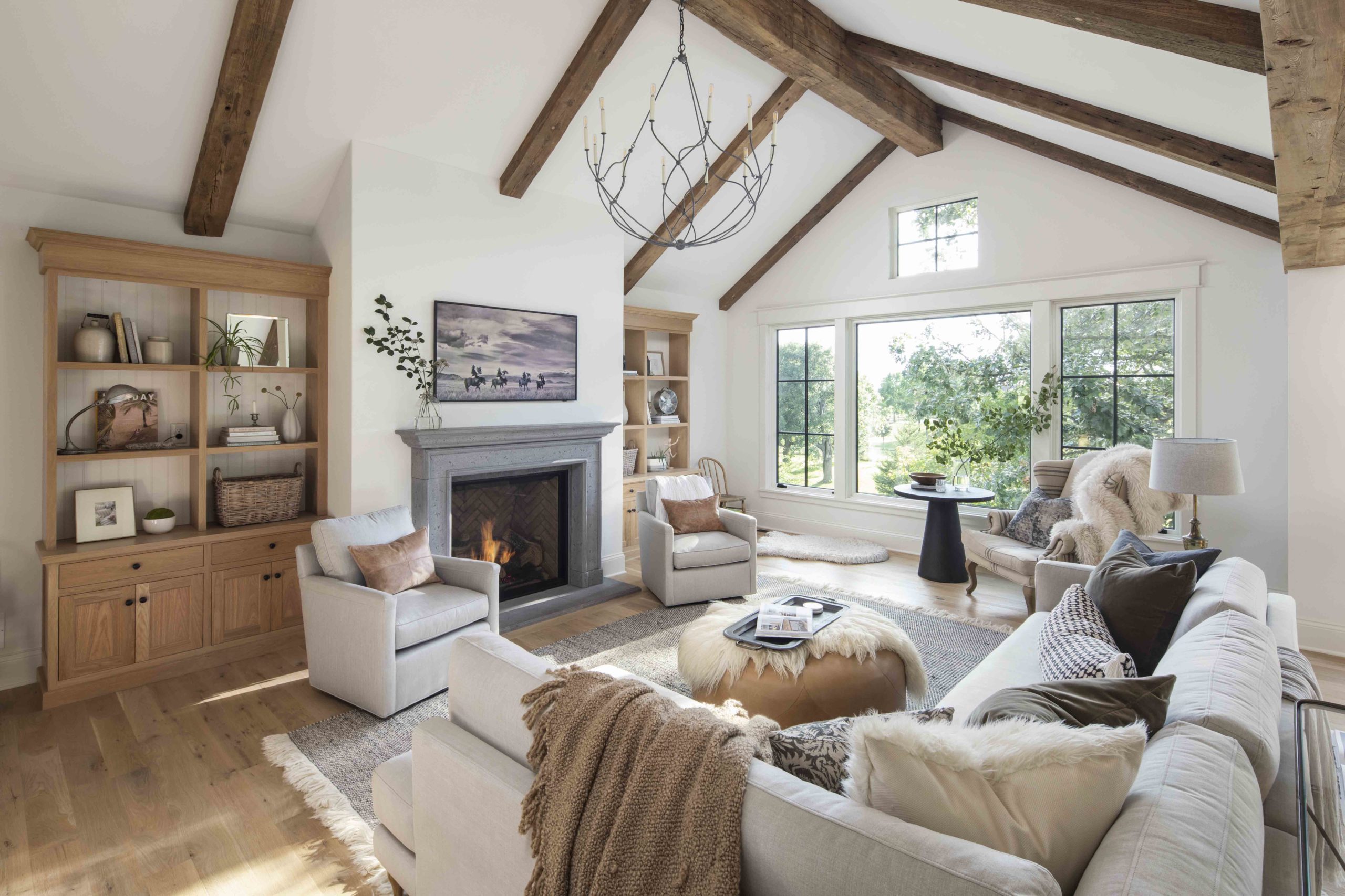 A prairie-style living room with wood beams and a cozy fireplace.