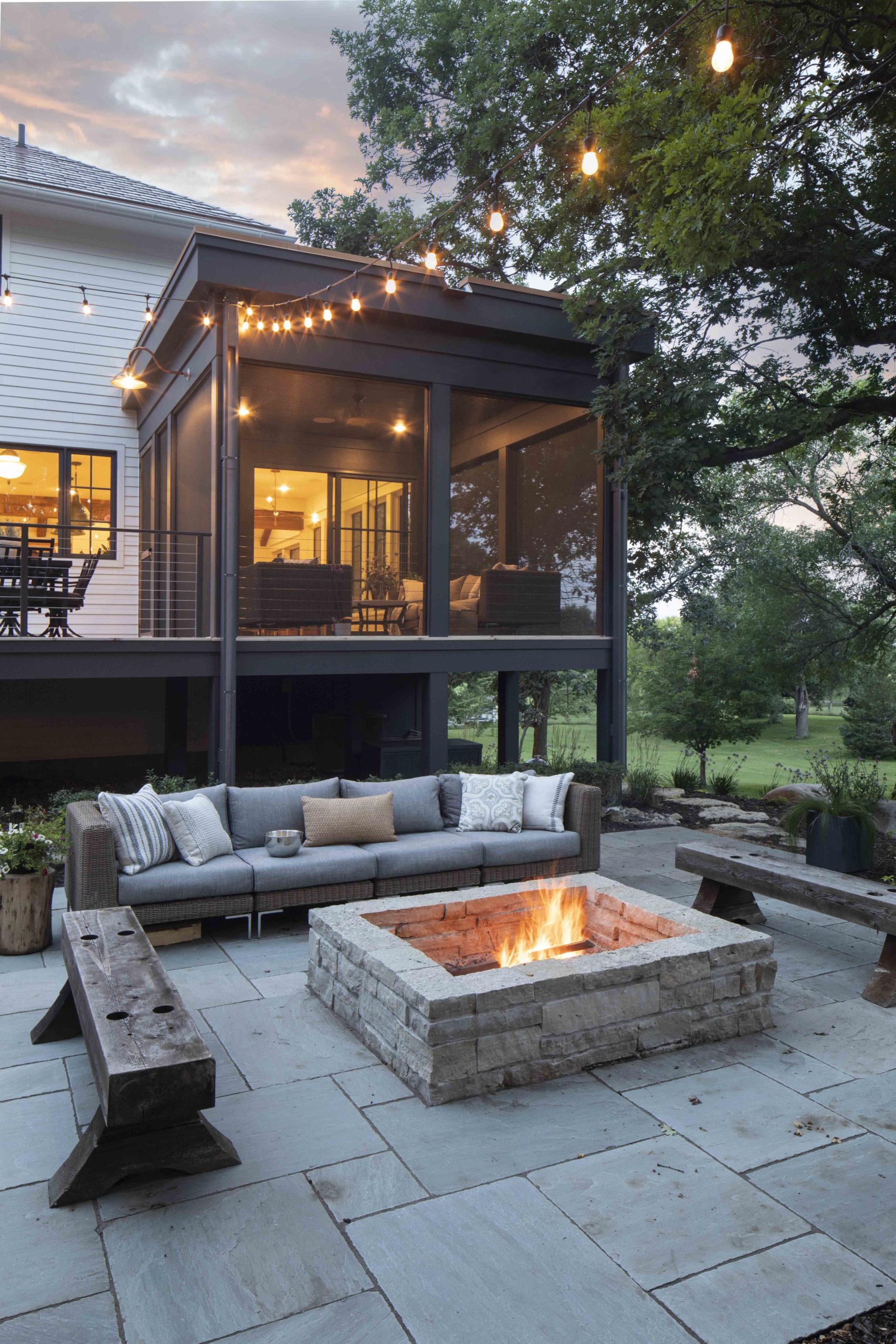 A prairie-style backyard with a fire pit and patio furniture.