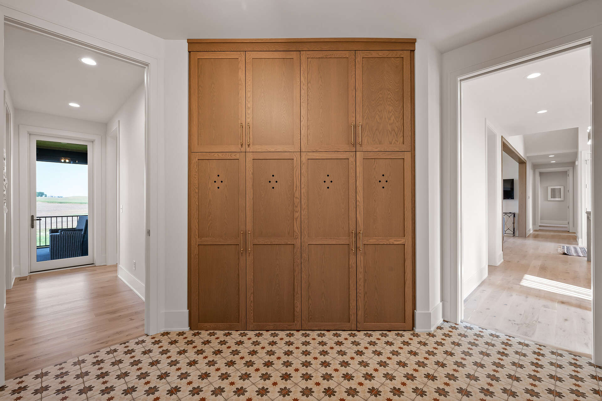 A prairie-style hallway adorned with wooden lockers and featuring a sleek tiled floor.