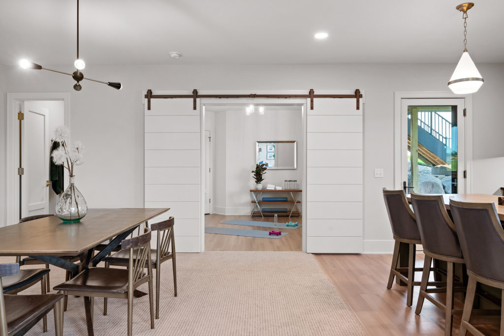 A prairie transitional dining room with a wooden table and chairs in a custom home.