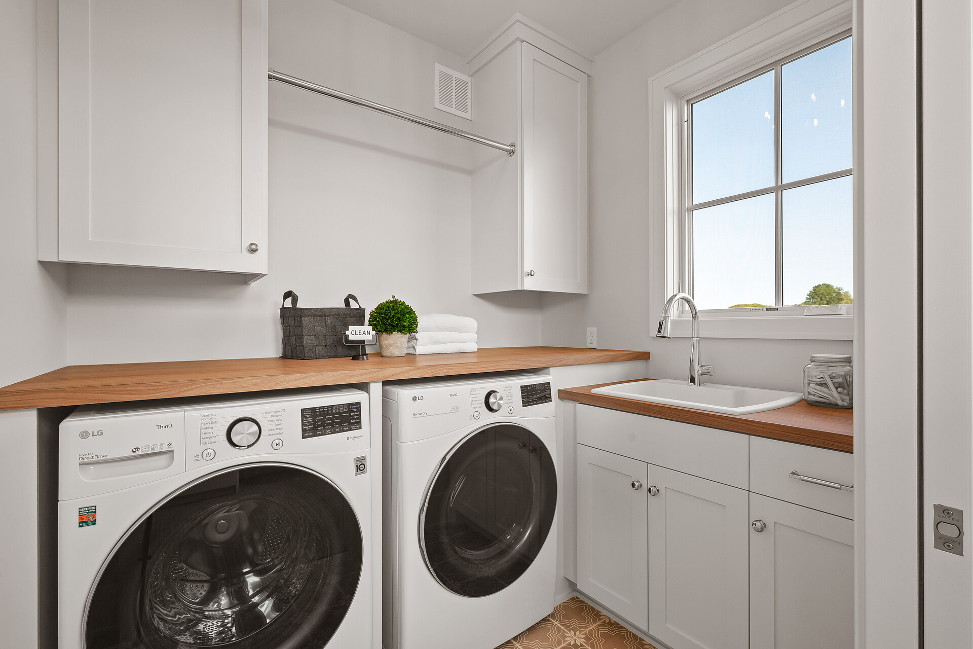 A prairie transitional laundry room with a washer and dryer in a custom home.
