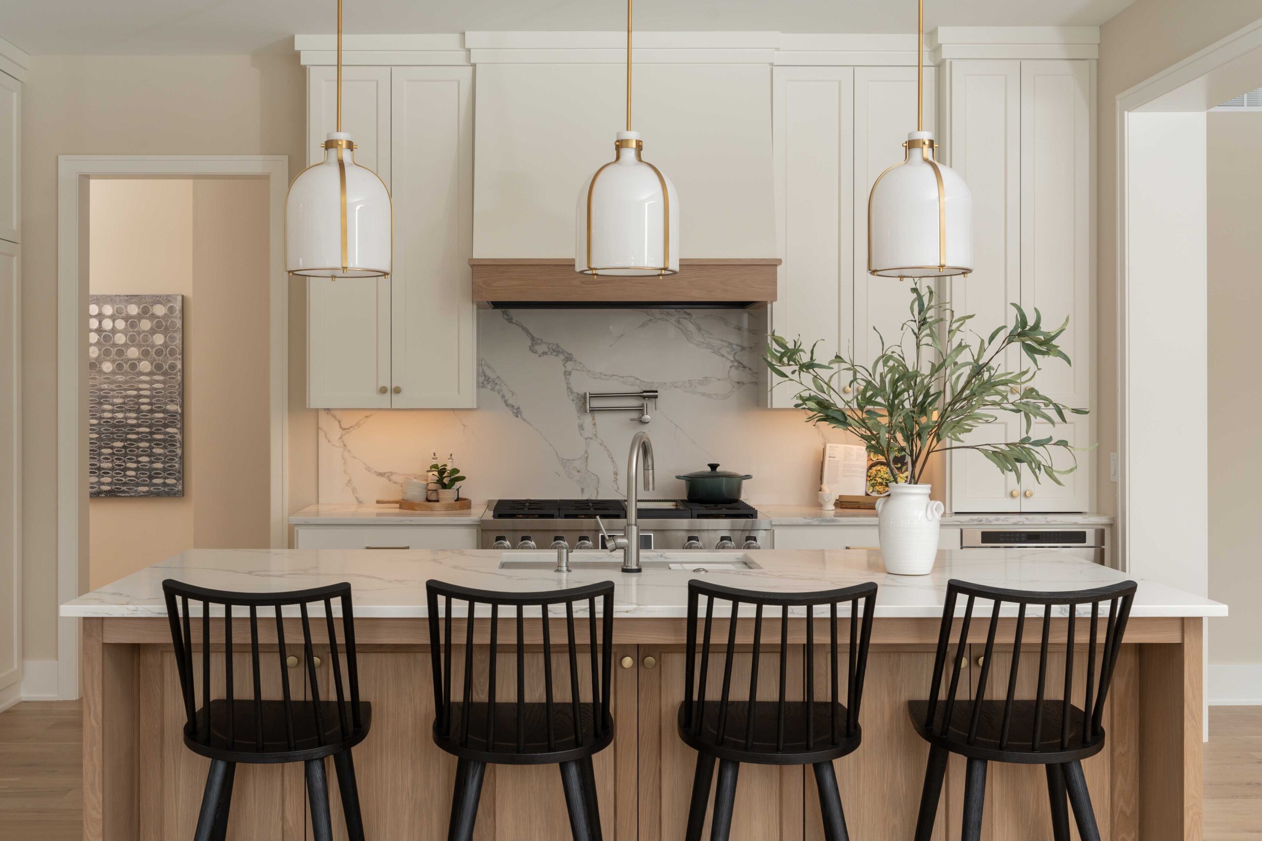 A kitchen in Eden Prairie with four black stools and a marble counter top.