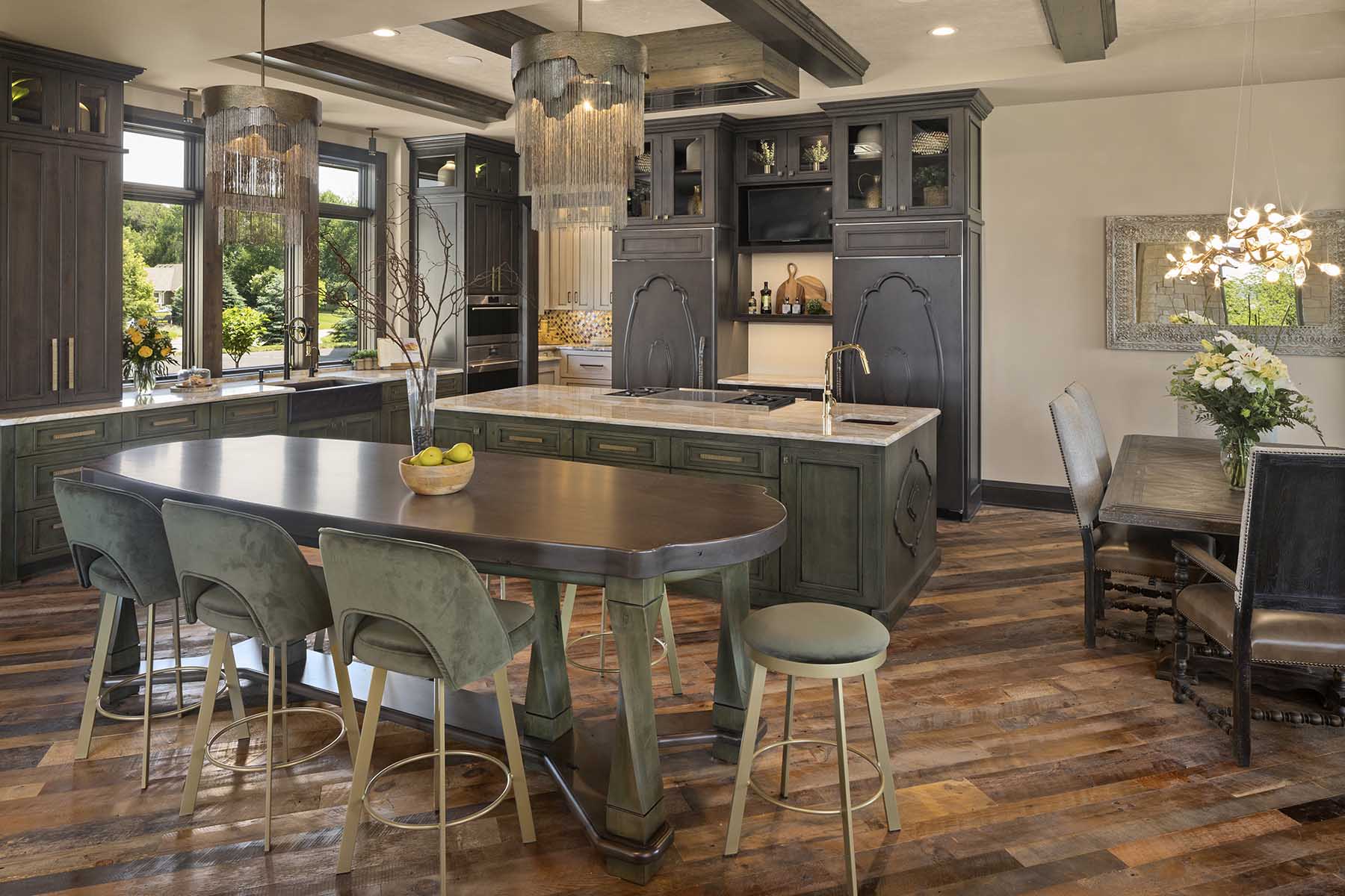 A modern kitchen with wood floors and a center island, located in a Tuscan Mediterranean home.
