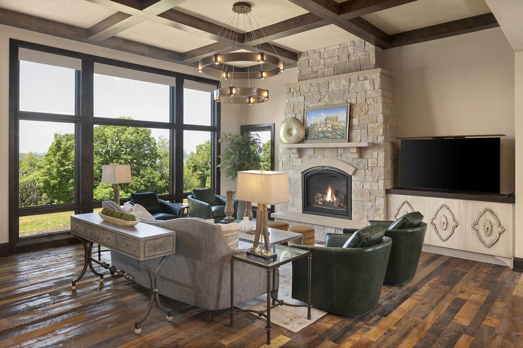 A modern living room in a Tuscan Mediterranean home, featuring wood floors and a fireplace.